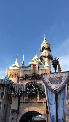 the entrance to disneyland's sleeping beauty castle is decorated with decorations and lights for christmas