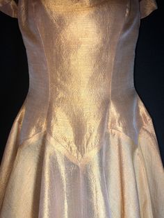 "Made by Harry Keiser, this is a dreamy organza dress in a lovely golden amber color. It has a grand sweeping hemline, a very light dress, you will want to wear a half slip under it, especially for reaching the fuller effect of the skirting. The only flaw is a black mark on the back, minor at best. I always recommend dry cleaning before wearing any vintage clothing. Bust 32-34\" Waist 26\" Hips free fitting Length from shoulder to hem is 47\"" Gold A-line Fitted Evening Dress, Gold A-line Evening Dress For Wedding, Gold Fitted A-line Evening Dress, Vintage Silk Evening Dress With Fitted Bodice, Vintage Silk Ball Gown, Vintage Silk Party Gown, Vintage Gold Evening Dress For Party, Vintage Gold Gown For Party, Vintage Gold Evening Dress For Wedding