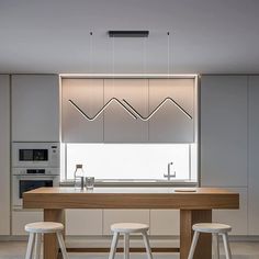 a kitchen with two stools next to a counter top and an oven in the background