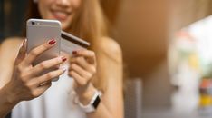 a close up of a person holding a cell phone in their hand and smiling at the camera