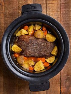 an overhead view of a pot roast with potatoes, carrots and meat in it