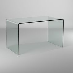 a glass table sitting on top of a white floor next to a gray wall in an empty room