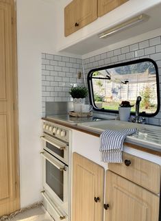 a kitchen area with an oven, sink and window