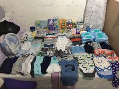 a bed covered in lots of baby items