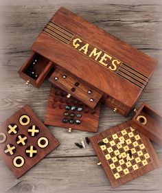 four wooden games in a box with the word games on it and two pieces of wood next to them