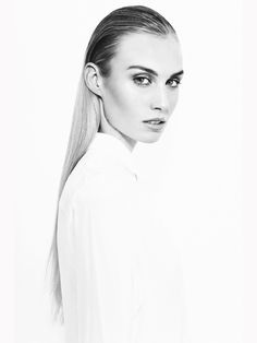 a black and white photo of a woman with long hair wearing a shirt over her shoulder