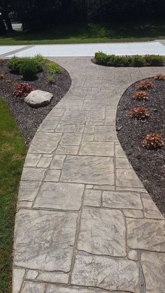 a stone walkway in the middle of a garden