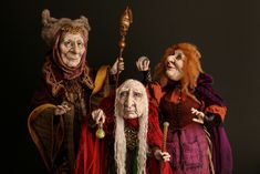 three people dressed up in costumes and holding wands