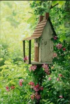 a bird house in the middle of some flowers