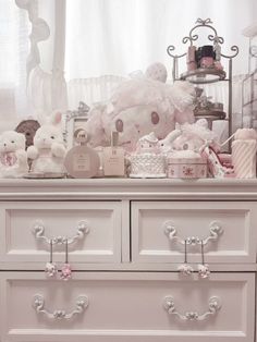 a white dresser topped with lots of stuffed animals