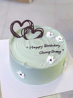 a birthday cake with white frosting and chocolate hearts on top that reads happy birthday, choong ghang