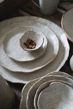 a table topped with white plates and cups