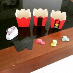 three red and white paper cupcakes sitting on top of a table next to a computer mouse