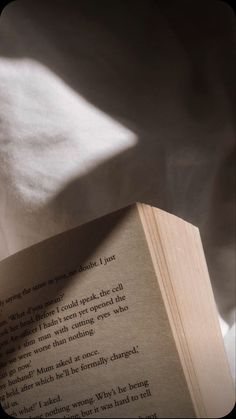 an open book sitting on top of a bed