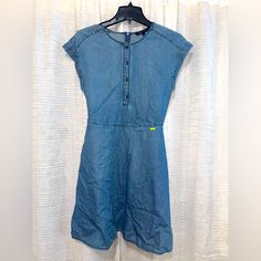 This Dress With A Romantic Attitude Is Made Of Cotton Chambray Denim: A Casual Fabric That In This Case Becomes Elegant And Refined. The Mood Of The Model Is Underlined By The Pinafore Construction With Button Opening, And Short Sleeves. Xs New And Never Worned Sleeveless Relaxed Fit Medium Wash Dress, Blue Casual Dress With Relaxed Fit, Casual Short Sleeve Denim Blue Dress, Casual Denim Blue Short Sleeve Dress, Blue Casual Relaxed Fit Dress, Denim Blue Cotton Casual Dress, Casual Knee-length Denim Dress, Casual Knee-length Denim Dress For Daywear, Casual Light Wash Short Sleeve Dress