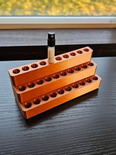 three orange legos stacked on top of each other with one bottle in the middle