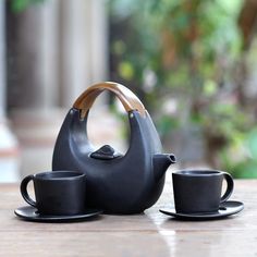 a teapot and two cups on a table