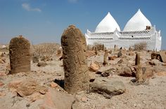 some rocks and white buildings in the desert