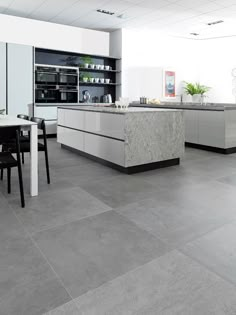 a modern kitchen with marble counter tops and black chairs in front of an island table