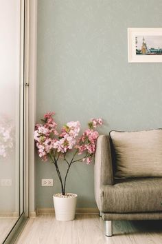 a living room with a couch and flowers in a vase