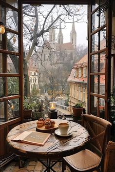 a table that has some food on it in front of an open window with a view of the city