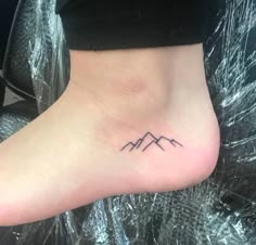 a small mountain tattoo on the ankle