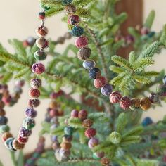 beads are hanging from the branches of a tree