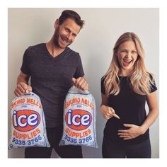 a man and woman holding two bags of ice cream