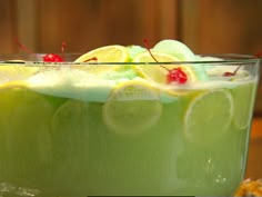 a green drink with lemons and cherries in it