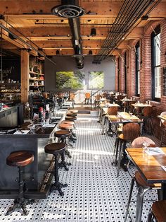 an empty restaurant with lots of tables and stools in it's center area