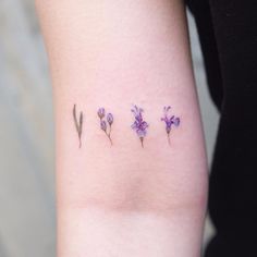 three small purple flowers on the left side of the arm, and one pink flower in the middle