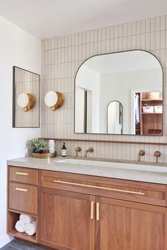 a bathroom with wooden cabinets and mirrors on the wall