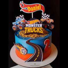 a birthday cake with monster trucks on it and a sign that says, daniel's monster trucks