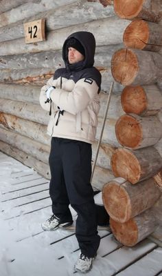 a person standing in front of a log cabin