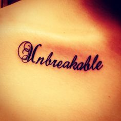 the word unbreakable written in cursive font on someone's upper back