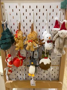 several stuffed animals are hanging from hooks on a rack