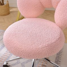 a pink chair sitting on top of a wooden floor