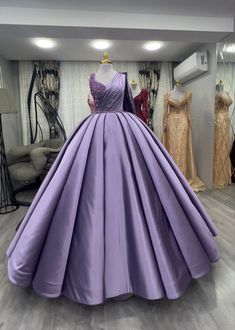 a purple ball gown is on display in a room with other mannequins