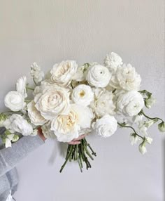 a person holding a bouquet of white flowers