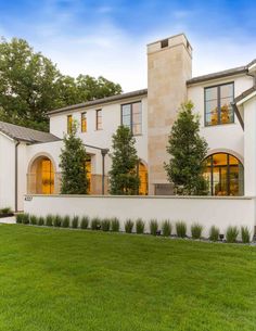 a large white house sitting on top of a lush green field