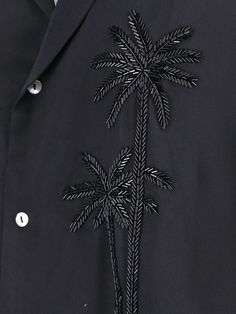 a black jacket with palm trees embroidered on it