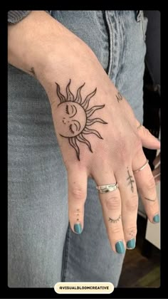 a woman's hand with a sun tattoo on it