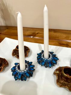 three candles are sitting on a plate with other items around it and one candle is in the middle