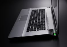 an open laptop computer sitting on top of a black table next to a mouse and pen