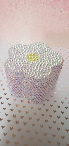 a small white box sitting on top of a table covered in confetti dots