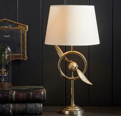 a lamp sitting on top of a table next to a book and an old clock