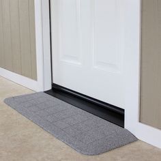 the door mat is on the floor next to the front door with an open white door