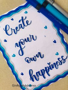 a piece of paper with the words create your own happiness written on it next to a pen