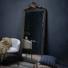 a chair sitting in front of a large mirror