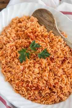 a white bowl filled with rice and topped with cilantro on a colorful napkin